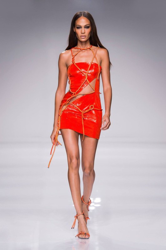 Joan Smalls walks Atelier Versace’s spring 2016 show wearing a red crop top and skirt with cut-out details