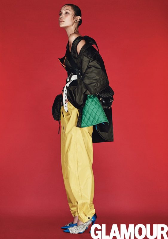 Bella Hadid models Prada jacket, top, corset, belt and bag with Patagonia pants and Balenciaga pumps