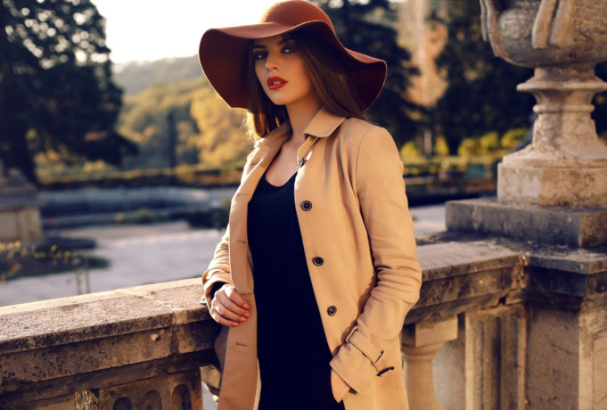 fashion outdoor photo of beautiful ladylike woman with dark straight hair wearing elegant coat and felt hat,posing in autumn park