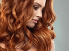 Beautiful model girl with long red curly hair .Red head . Care and beauty hair products