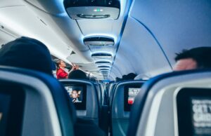 How to Stay Calm and Arrive Refreshed After a Long Flight flight attendant packing bags in the overhead locker