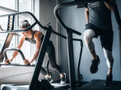 A woman a man using a running machine in a gym