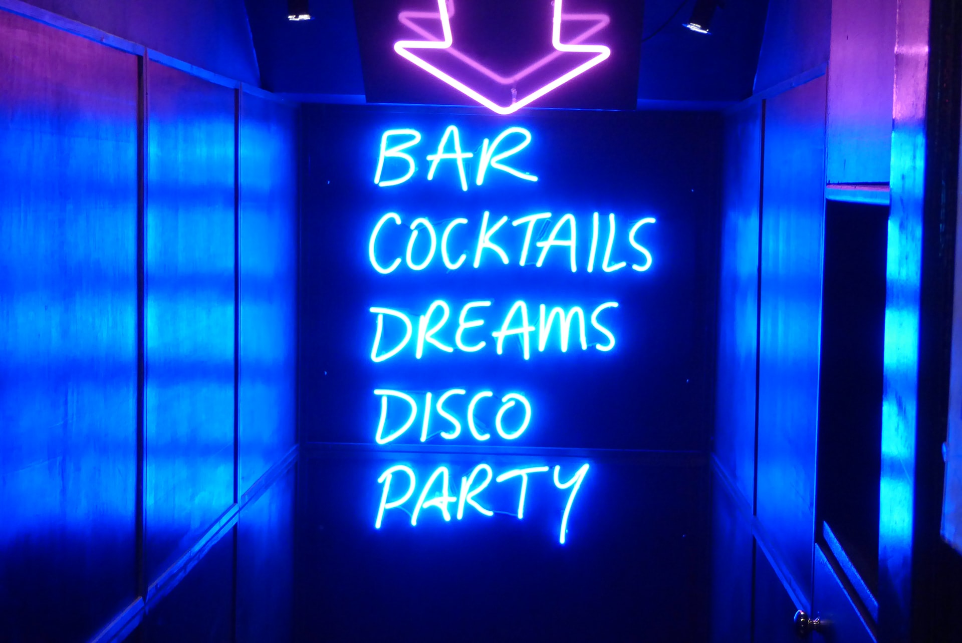 photo a stairway leading to a disco party with the words Bar, Cocktails, Dreams, Disco, Party written in Neon Lights