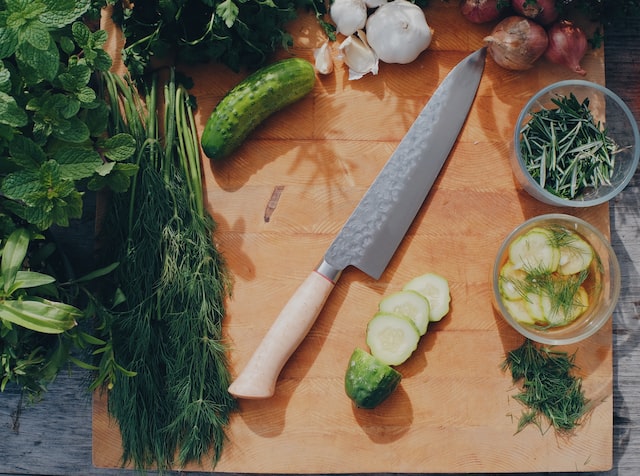 Kitchen knife and sliced cucumbers on a chopping board