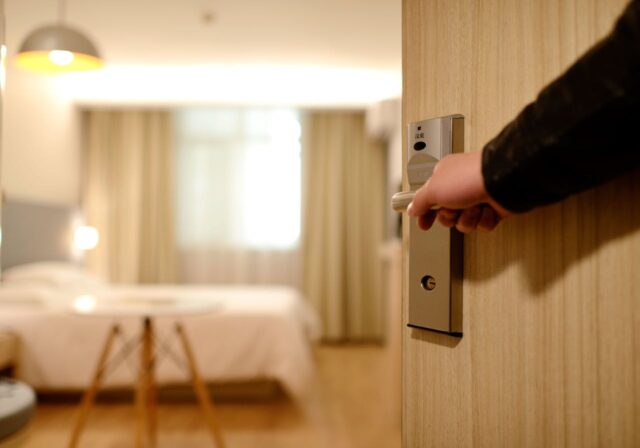 Elevate your gifting with hotel and dining out gift cards Person Holding on Door Lever Inside Room