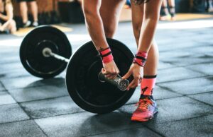 Must-Have Accessories to Boost Your Strength Training Person locking gym plates on barbell