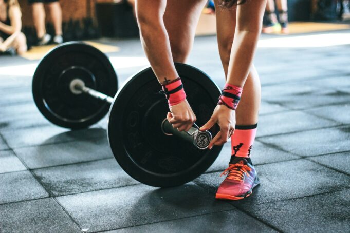Person locking gym plates on barbell