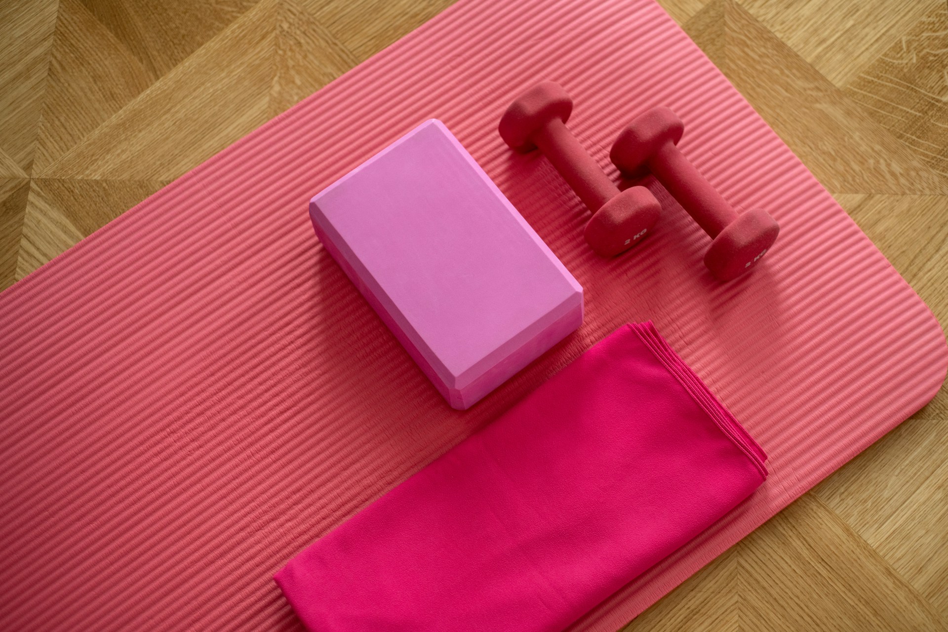 Pink dumbell on a pink yoga mat