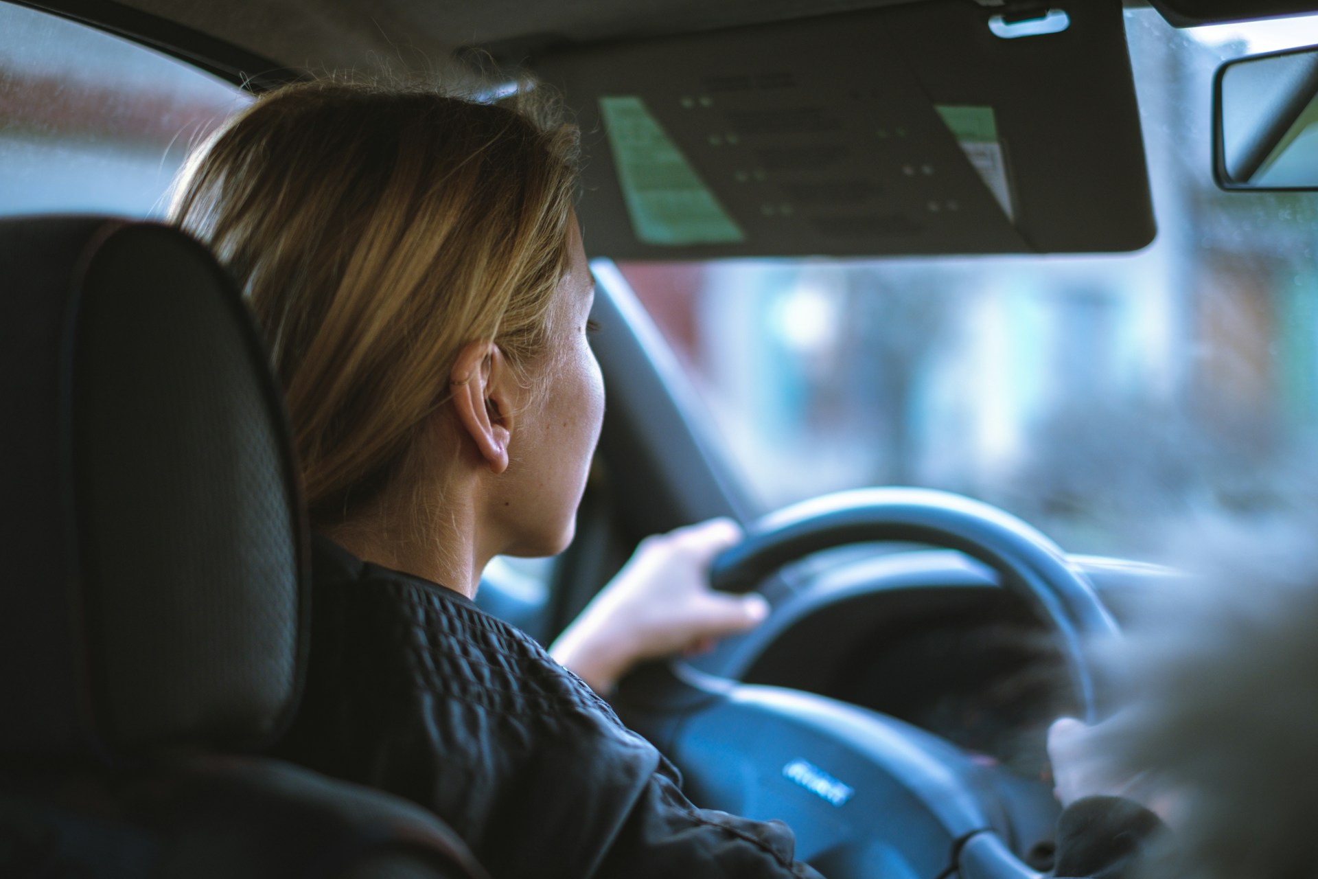 Women sitting in a car with a steering wheel