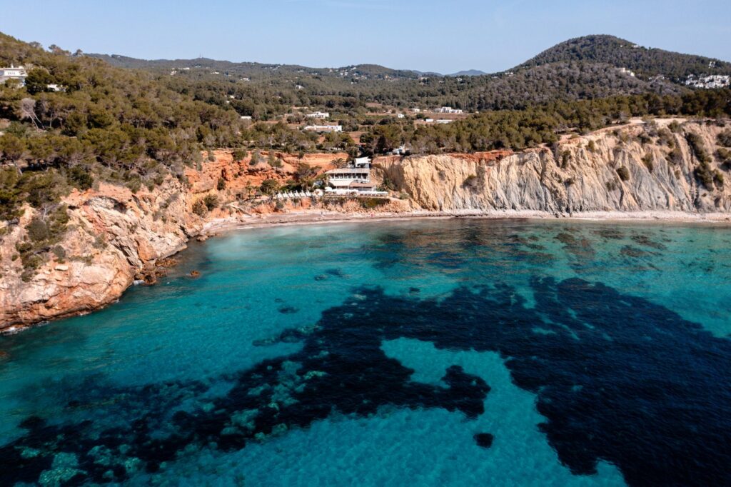 Aerial view of Sol d'en Serra Bay and the Amante Ibiza clifftop, Ibiza