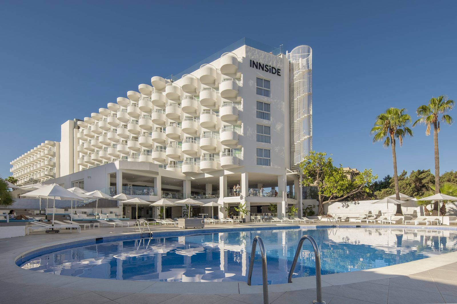 Pool and palm trees at INNSiDE Ibiza Beach