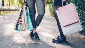 Two women with shopping bags on a sidewalk