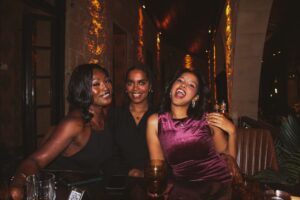 Three women laughing together at a table