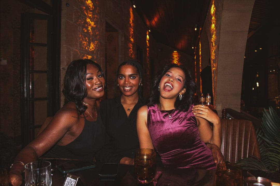 Three women laughing together at a table