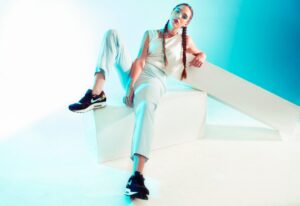 a woman sitting on top of a white block