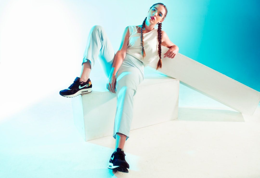 a woman sitting on top of a white block