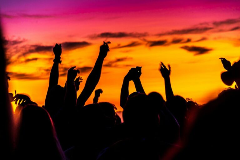 Festival crowd with raised hands at sunset