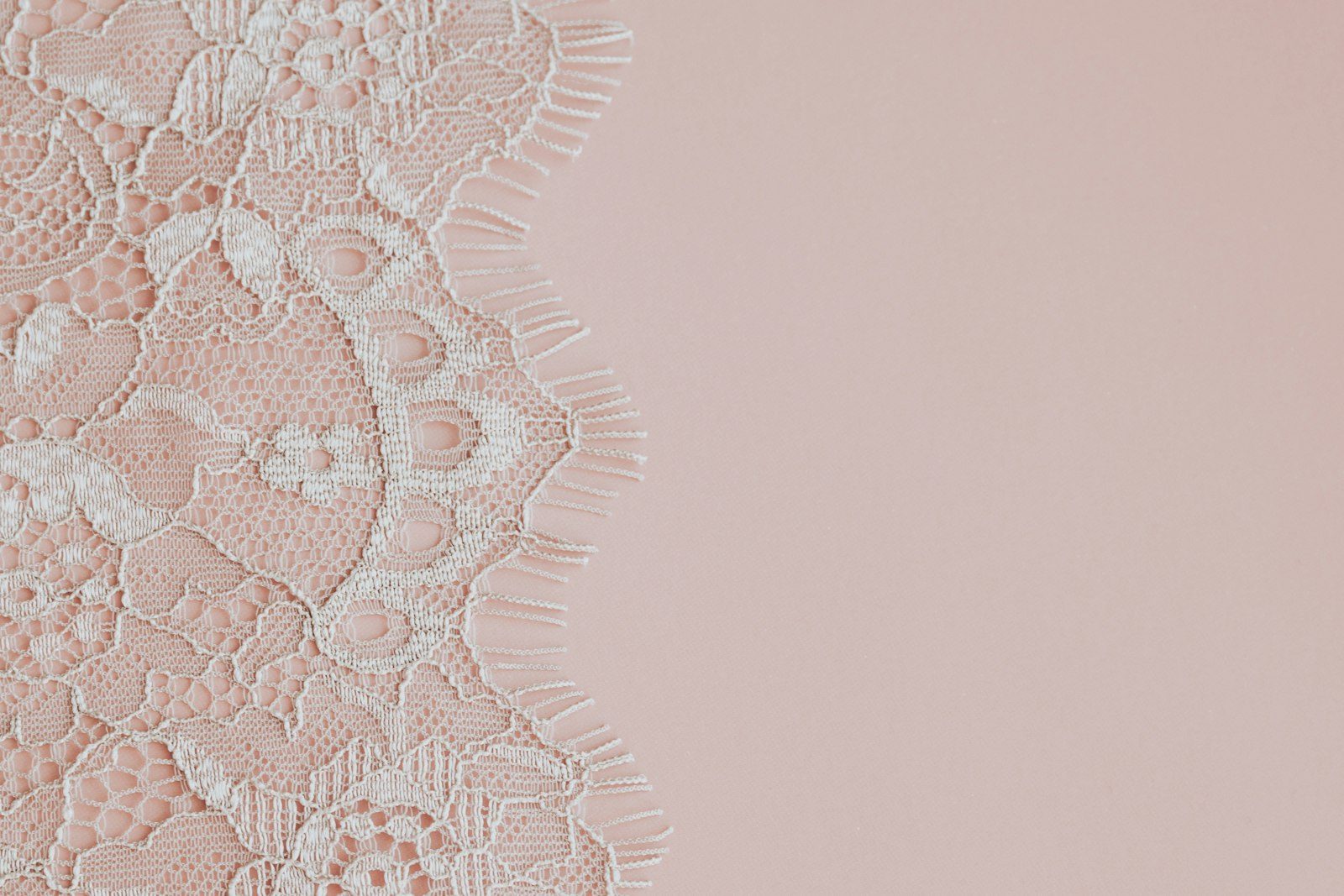 Delicate white lace on a soft pink background