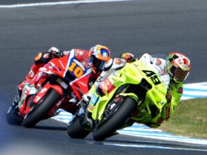 Motorcyclists race on a track during a competition.