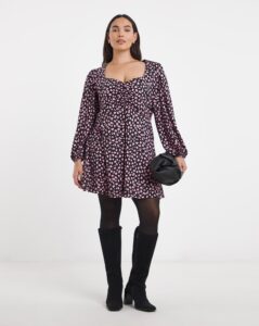 Photo of a women wearing a dress, tights and knee high boots