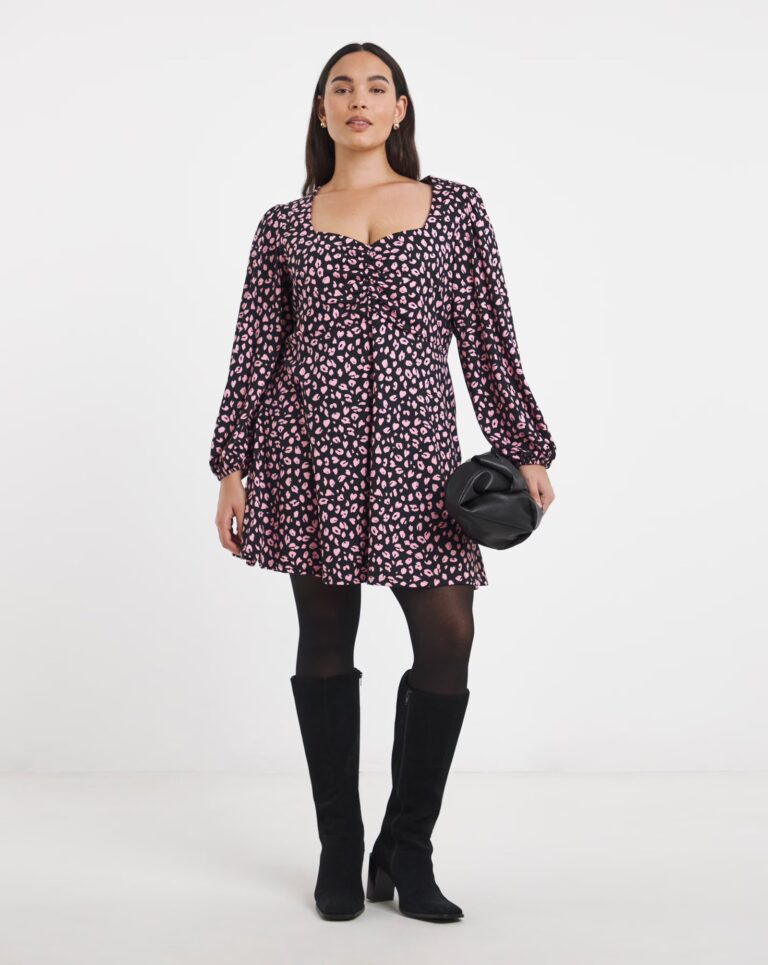 Photo of a women wearing a dress, tights and knee high boots