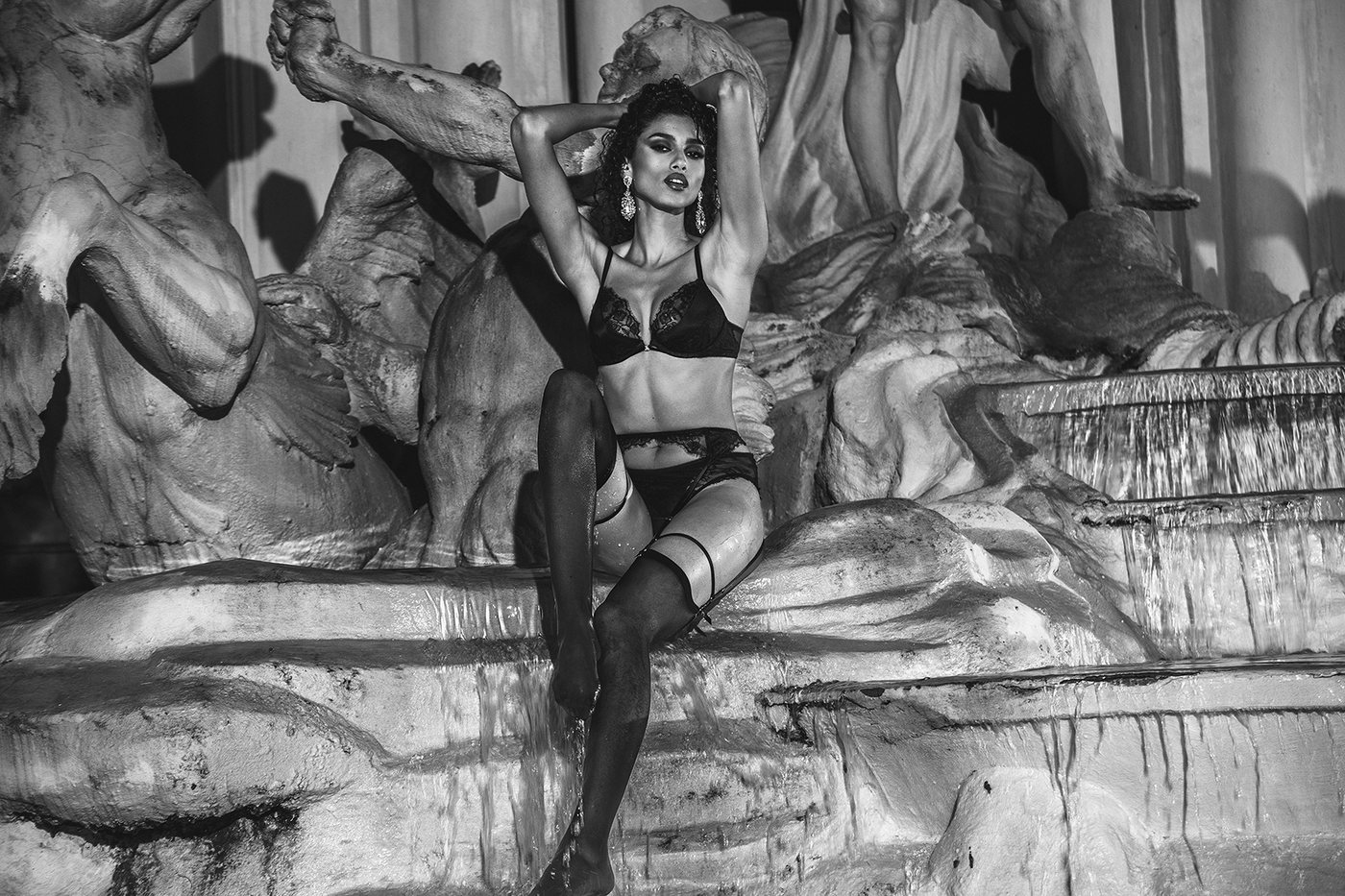 Imaan Hammam in a Victoria's Secret Very Sexy push-up bra, knickers and garter belt against Roman statuary