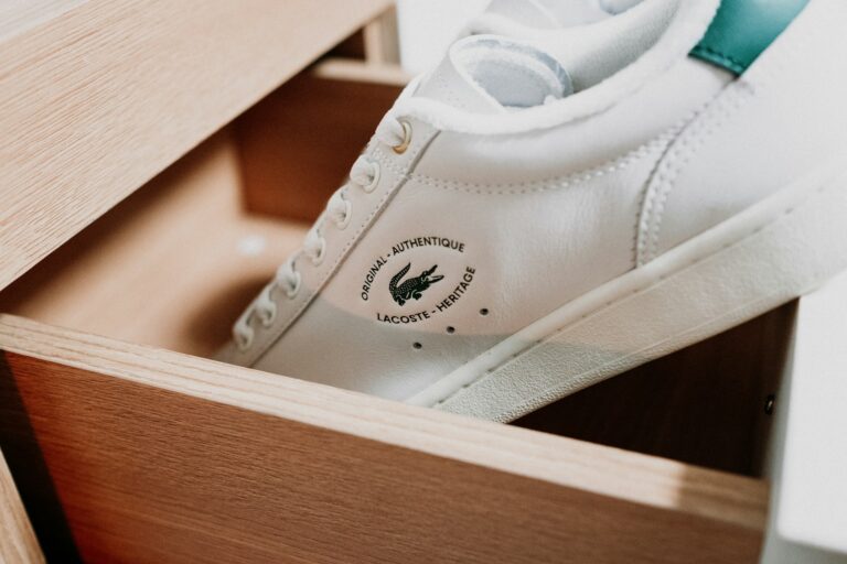 A pair of white trainers inside a wooden box