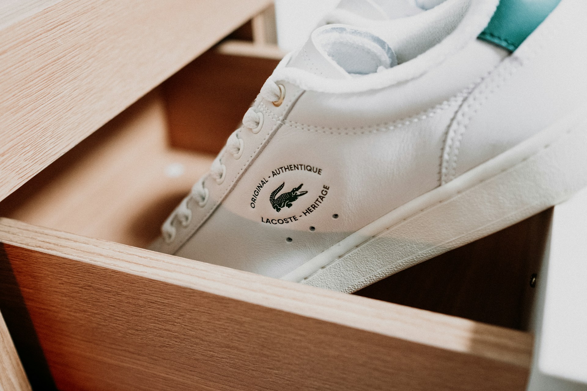 A pair of white trainers inside a wooden box