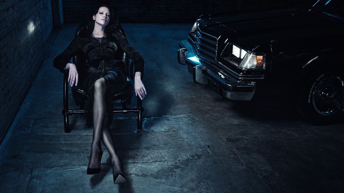 Irina Shayk in black Agent Provocateur Bernadette lace and stockings on a chair in a dark garage