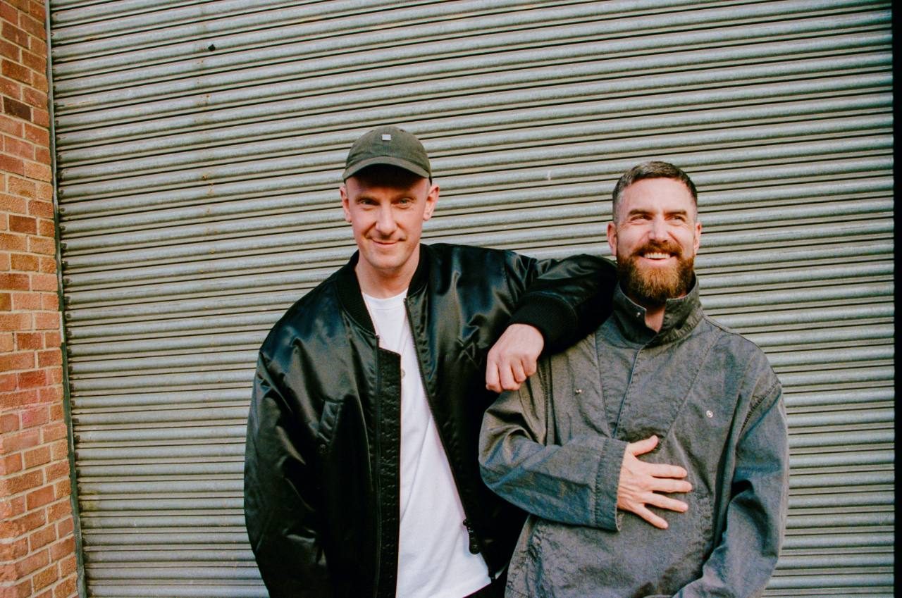 BICEP posing together in front of a metal roller shutter.